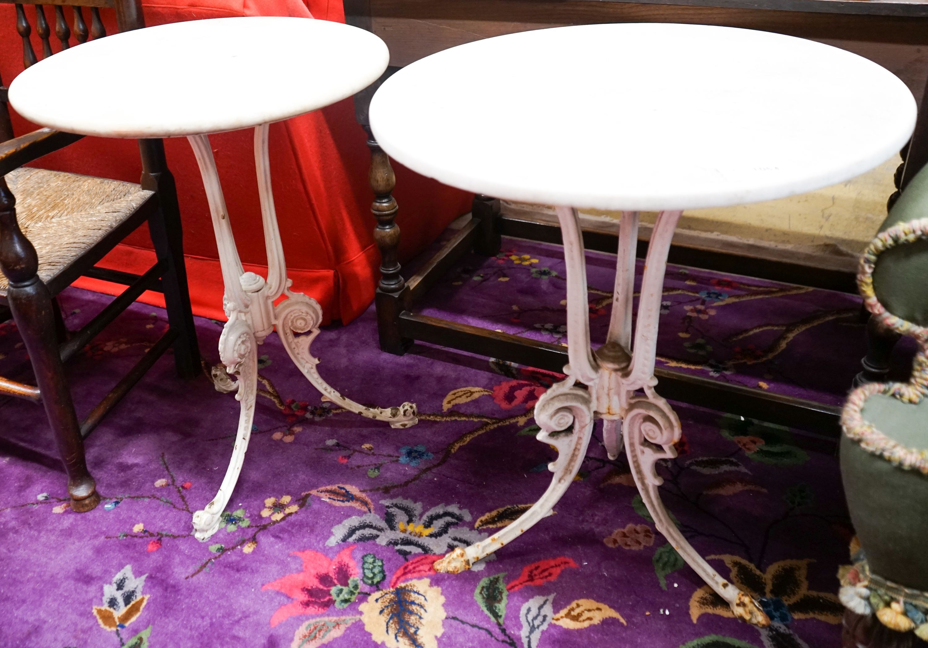 A near pair of painted cast iron circular marble top tables, larger 60cm diameter, height 71cm